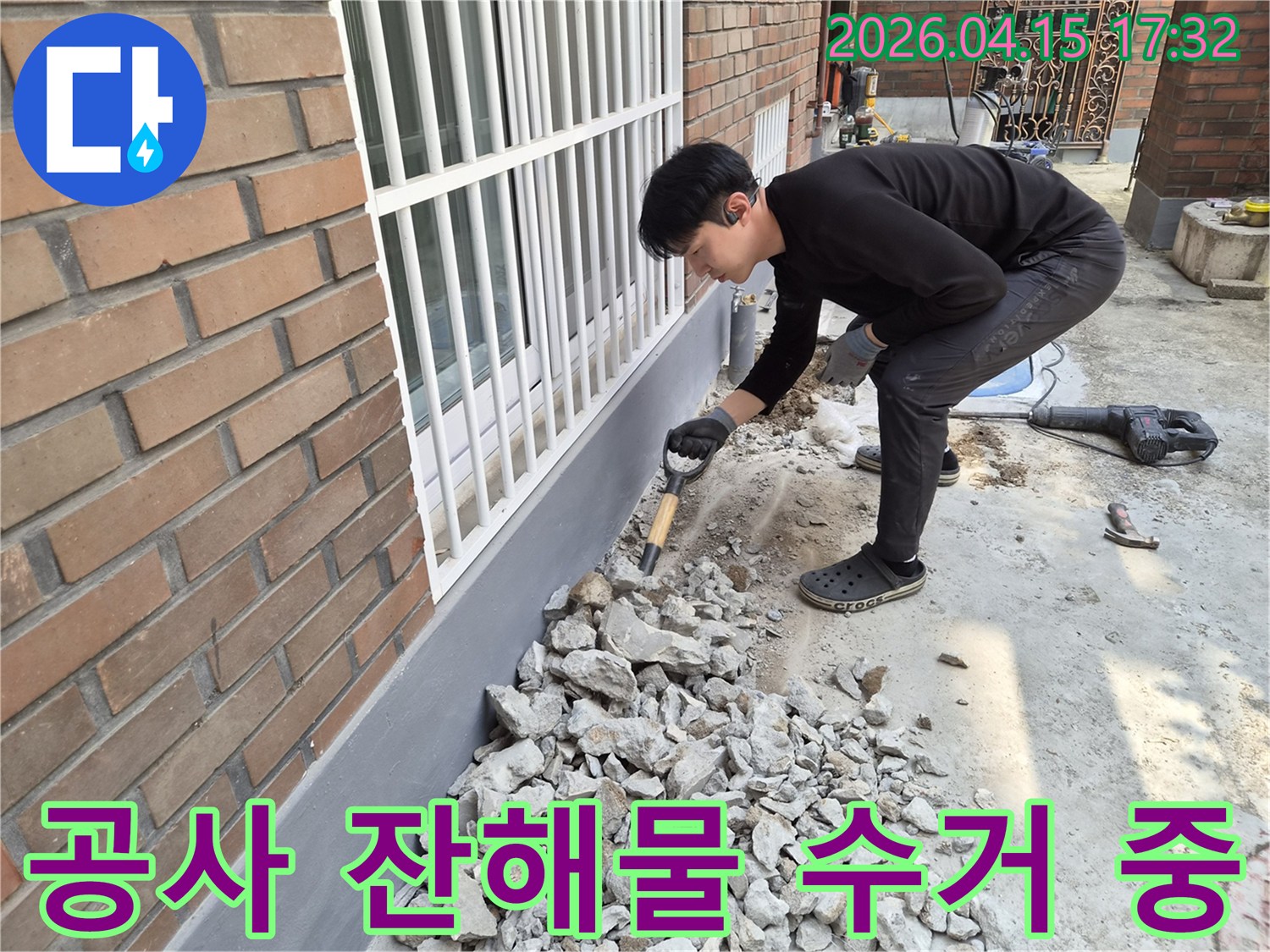 누수 공사 현장에서-작업자가 발생한 잔해물을 수거하는 중입니다