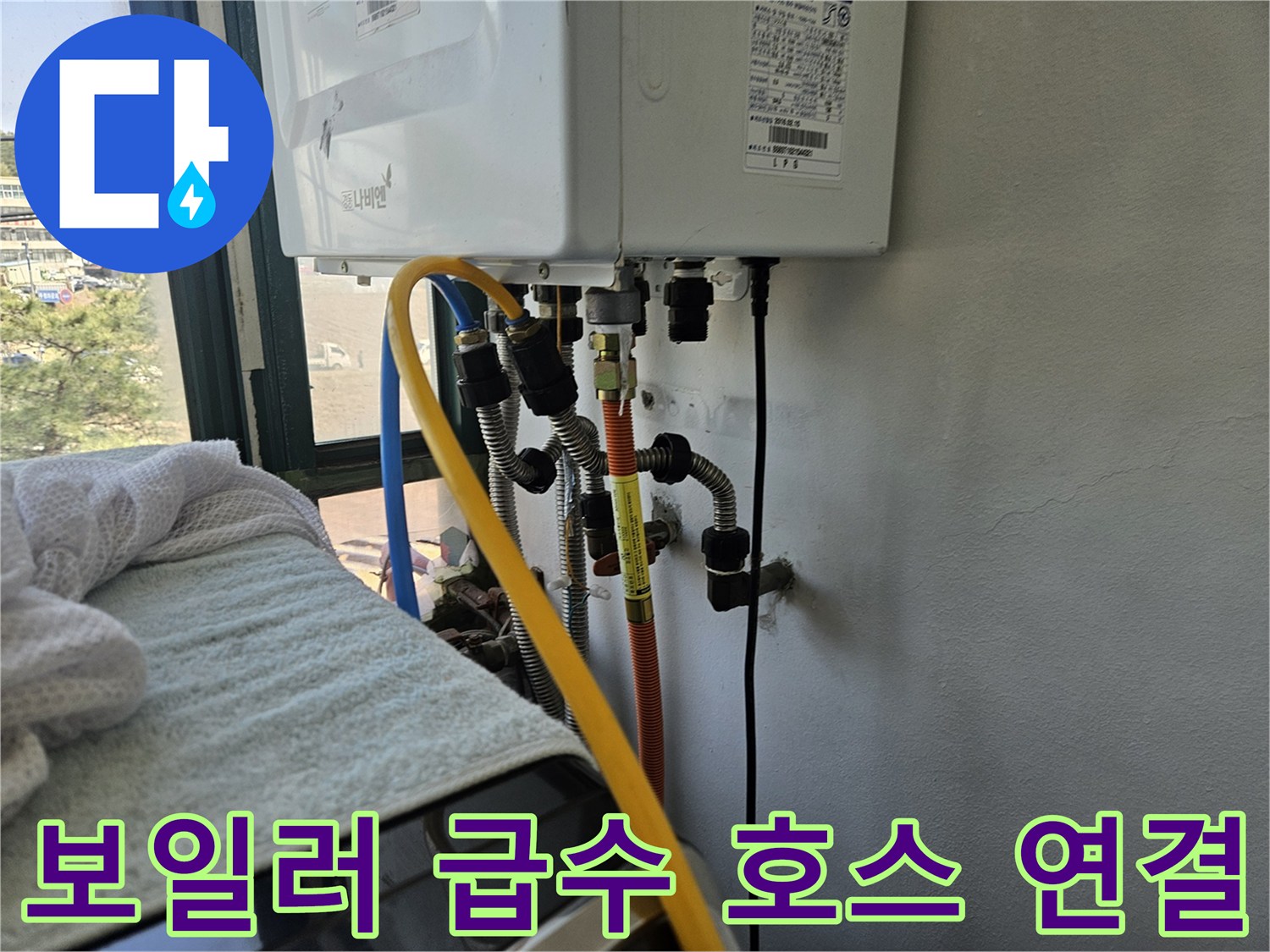 노란색과 파란색 유연한 호스가 보일러에 연결된 모습입니다.