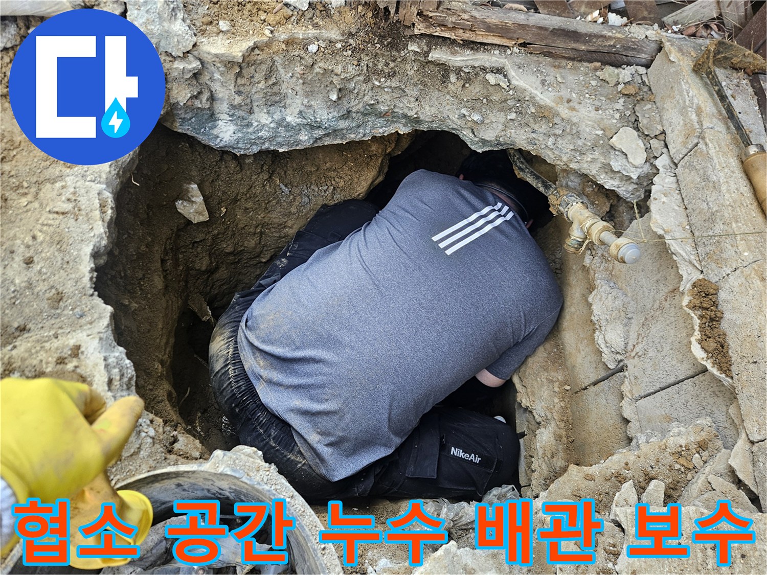 누수 전문 기술자가-좁고 깊은 구덩이 안에서-배관 누수 지점을-세심하게 보수하는 작업 현장