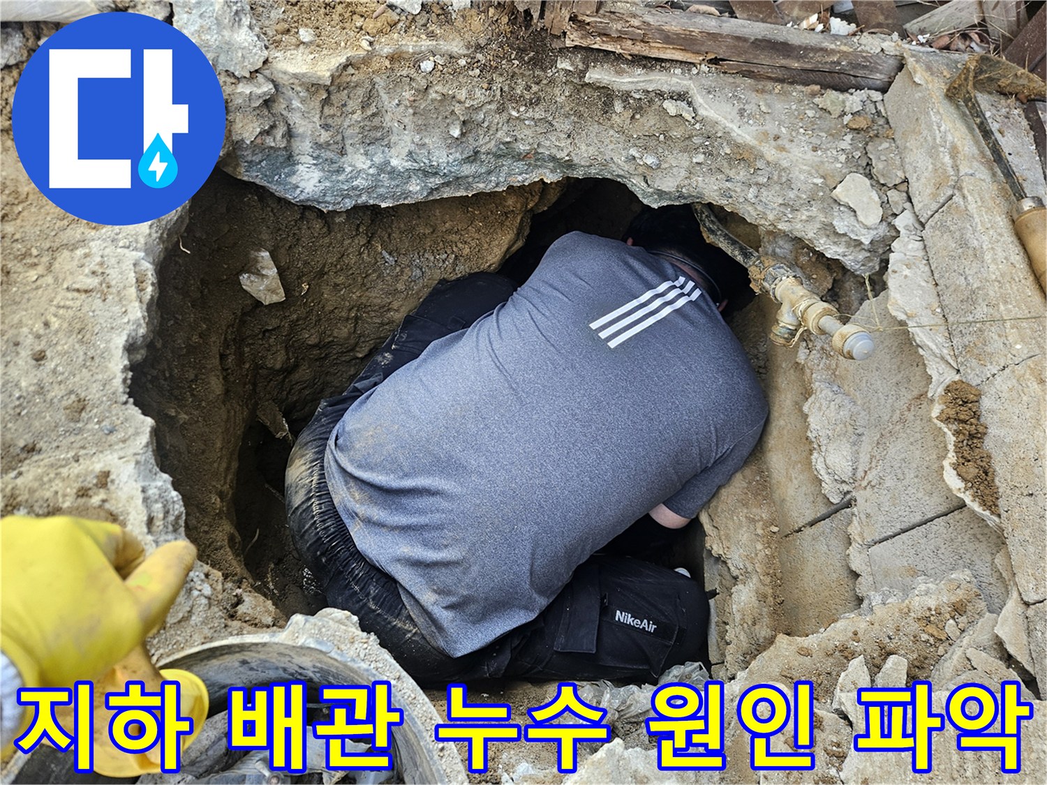 전문 누수 엔지니어가-땅속 깊이 파헤쳐진 공간에서-누수된 배관의 상태를-면밀히 확인하는 모습