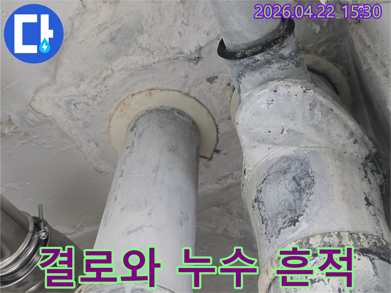 아파트 천장 배관 주변에-결로와 누수로 인해 발생한-복합적인 습기 흔적을 보여주는 사진입니다.