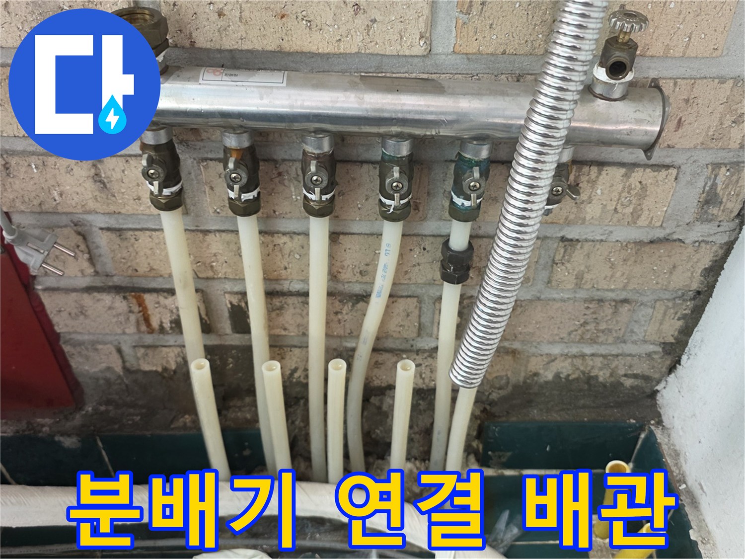 벽돌 벽면에 고정된-다수의 배관이 연결된-분배기 구조