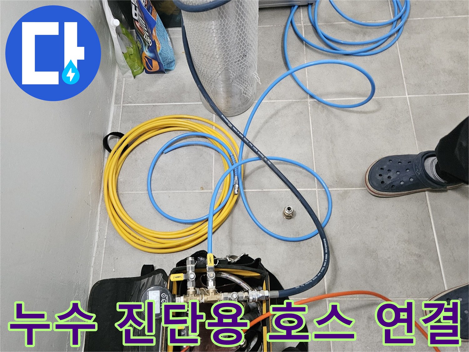 바닥에 배치된 파란색과 노란색의 검사용 배관 호스들