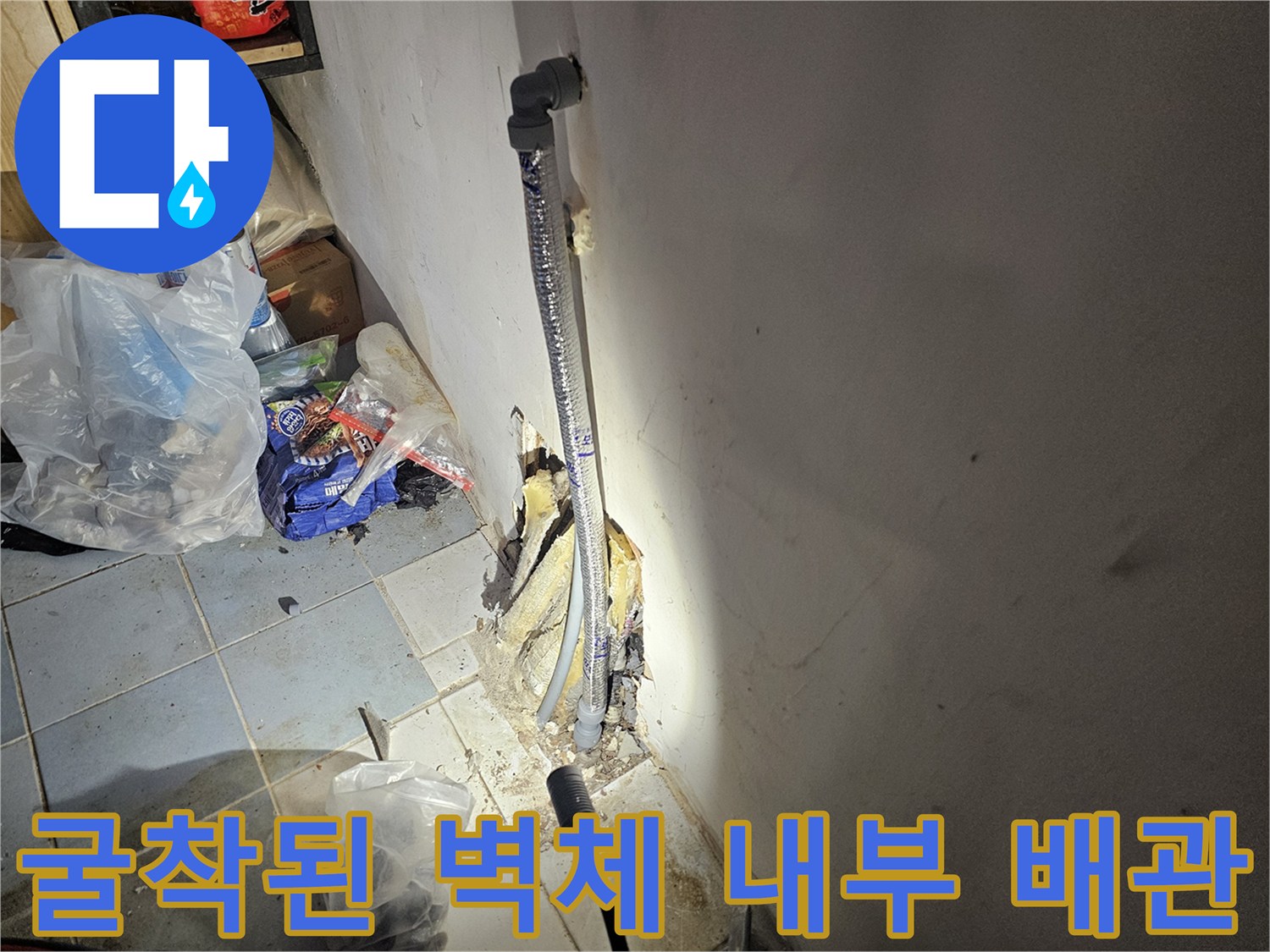벽면 굴착 부위-노출된 배관의 연결 상태와 보온재 손상 여부를 점검하는 장면입니다.