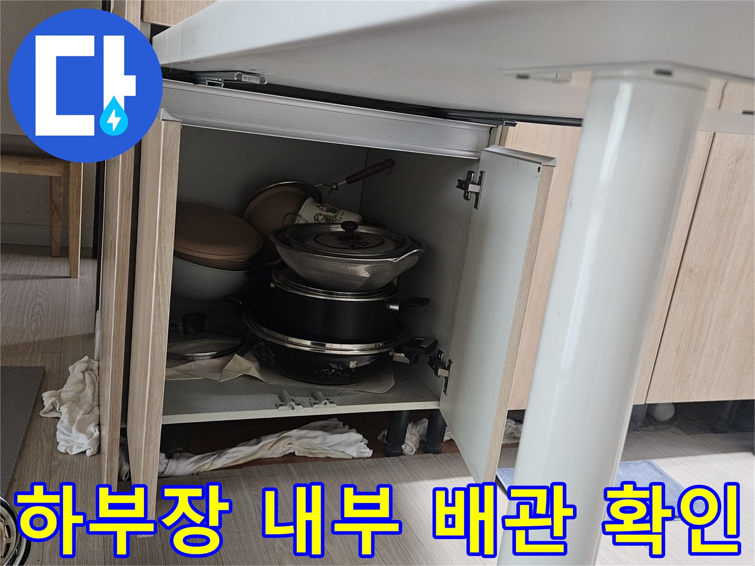 싱크대 하단 수납함 내부에 보관된 냄비와 주변 배관 부위