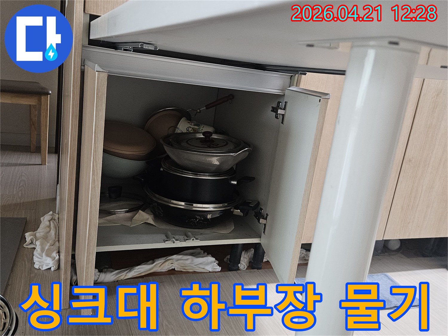 싱크대 하부장 내부에서 발견된-물기로 젖은 주방용품과-배관 노후로 인한 누수 현장