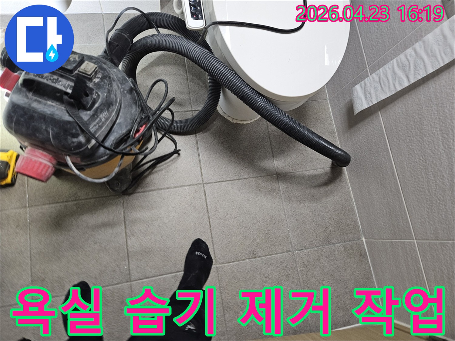 오산시 고객 댁 욕실에서-누수 엔지니어가-변기 주변의 습기를-습식 청소기로 제거하며-누수탐지 준비를 하는 모습