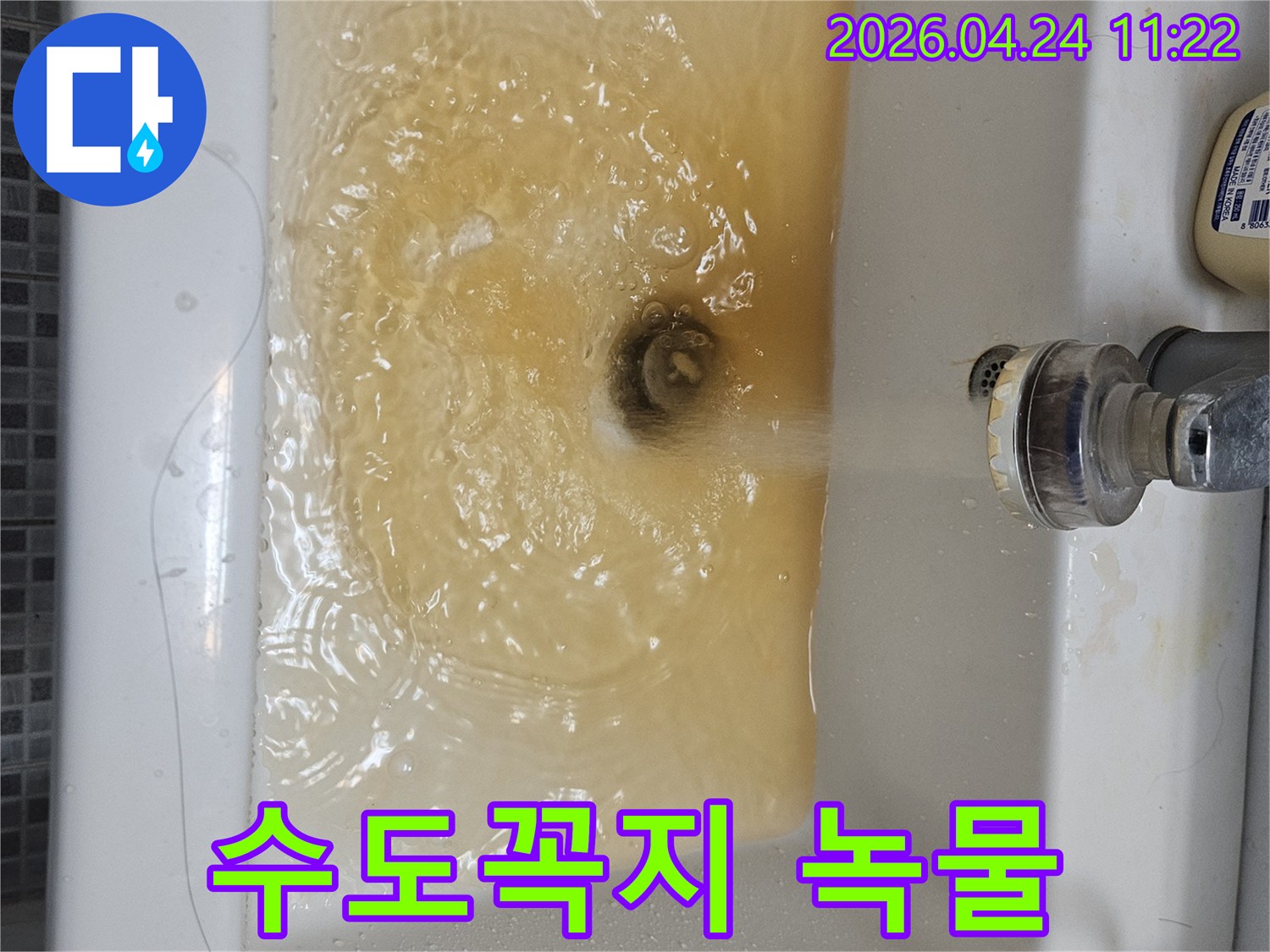 녹물이 흐르는 수도꼭지와-오염된 물로 채워진 세면대의 모습입니다-수도관 문제의 심각성을 알 수 있습니다.