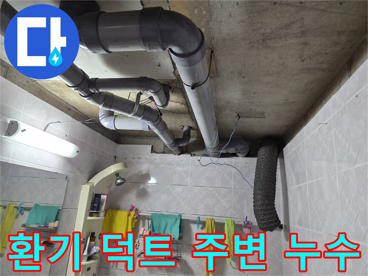 이 이미지는 욕실 천장에 설치된-환기 덕트와 주변 배관들을 보여주며-환기 덕트 주변에서 발생할 수 있는-누수 문제의 현장을 담고 있습니다