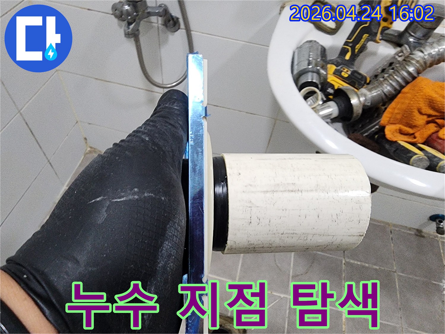 작업자가 배관 연결 부위를-손으로 직접 만져보며-누수 흔적을 탐지하고 있습니다