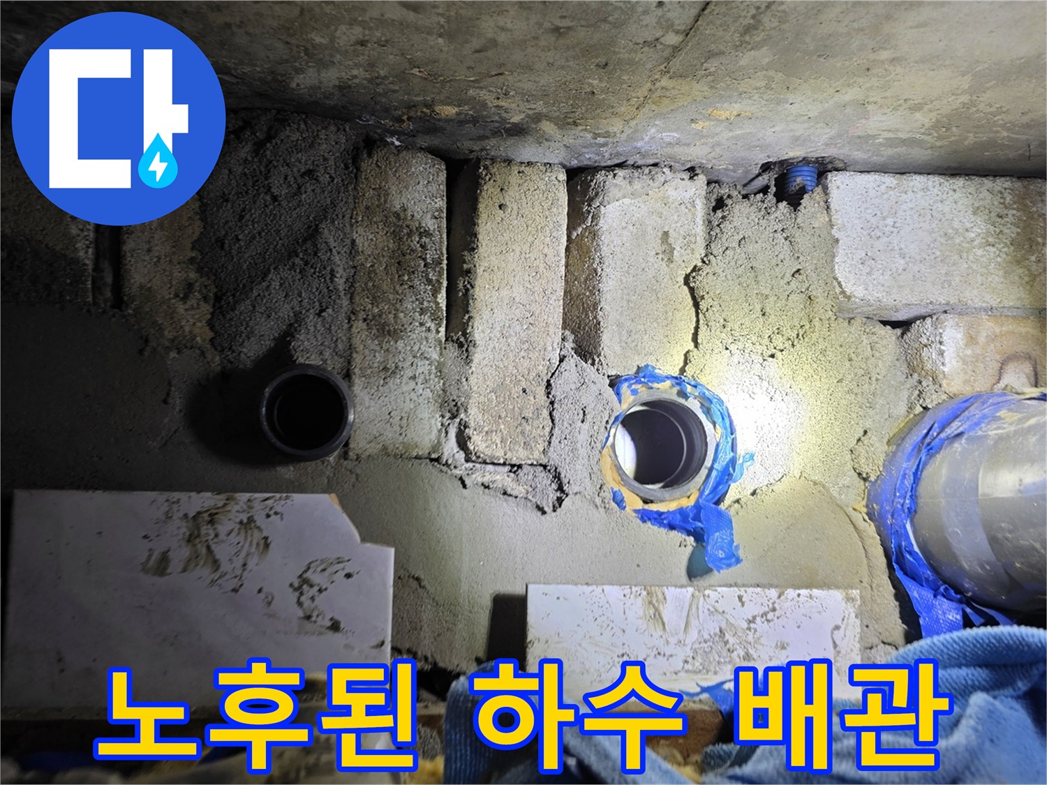 오염된 벽돌 구조물 사이에 위치한-노후된-하수 배관 부위