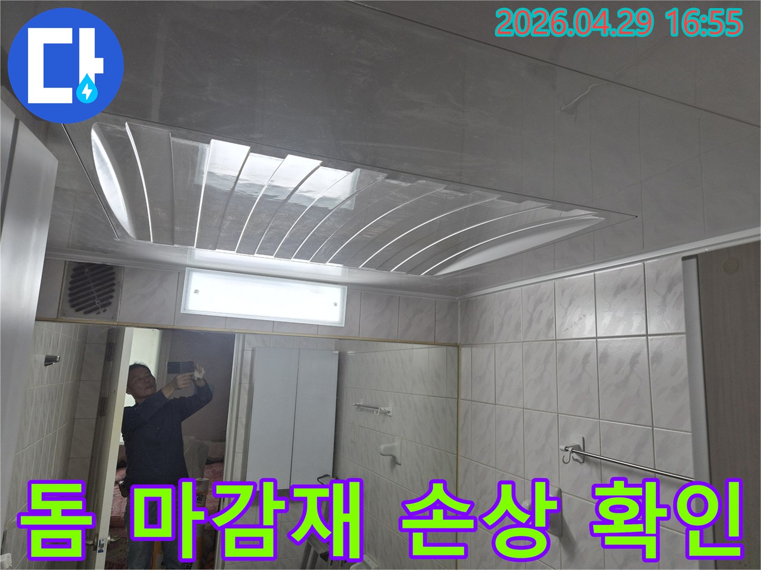 욕실-천장의-돔-형태-마감재와-조명-그리고-거울에-반사된-엔지니어의-모습이-담긴-누수-현장-점검-사진