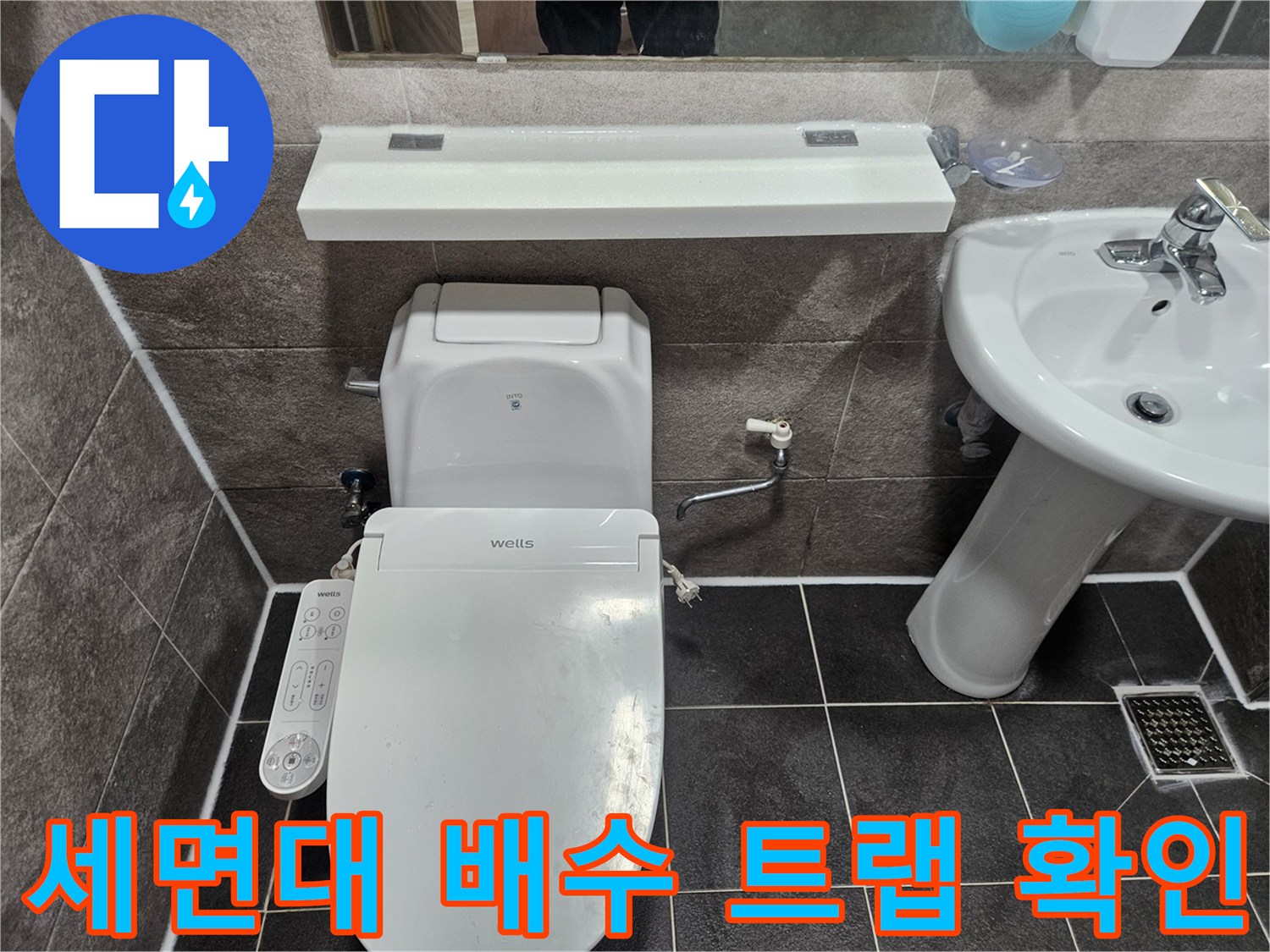 안양 만안구 청호아파트 화장실에서-세면대 아래 배수관 트랩의 누수 여부를 엔지니어가 점검하고 있습니다