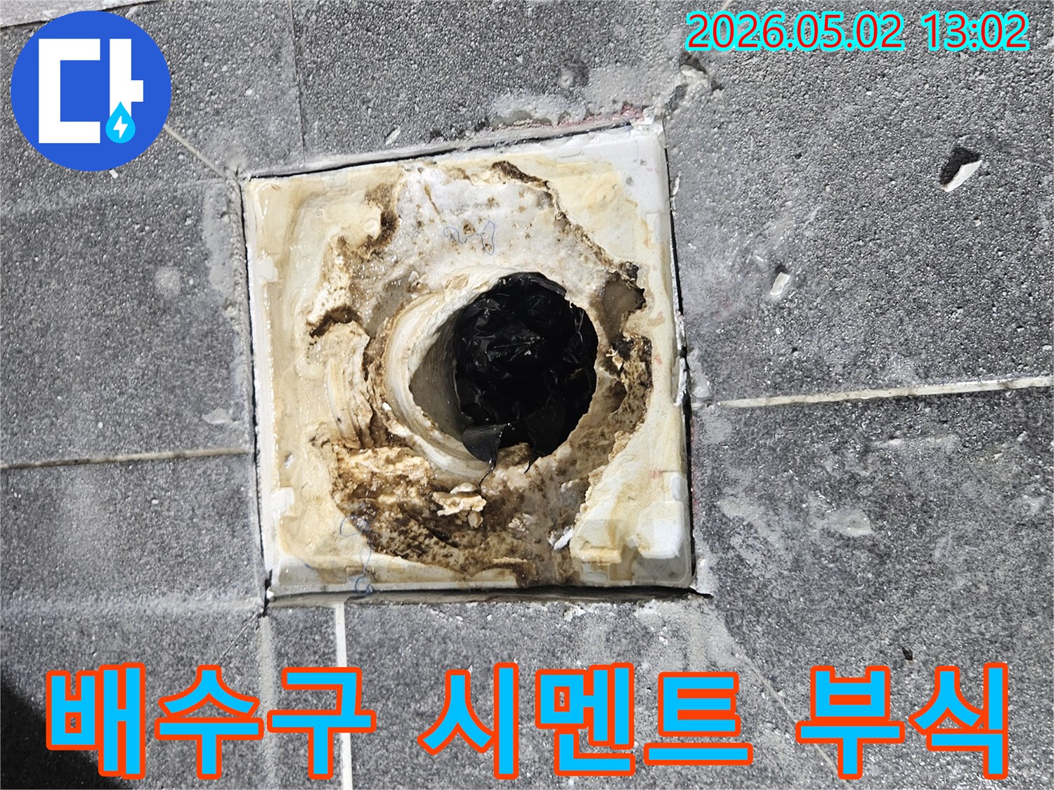 욕실 배수구 주변의-시멘트가 누수로 인해-심하게 부식되고-파손된 상태를-보여주는 사진입니다