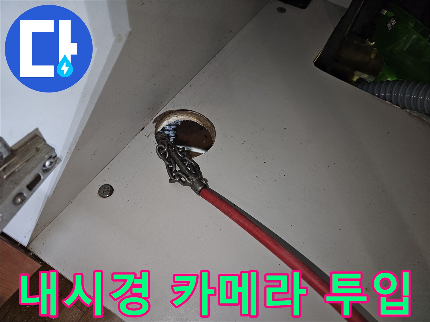 싱크대 하부 배수관 입구에 내시경 장비를 넣는 모습입니다.