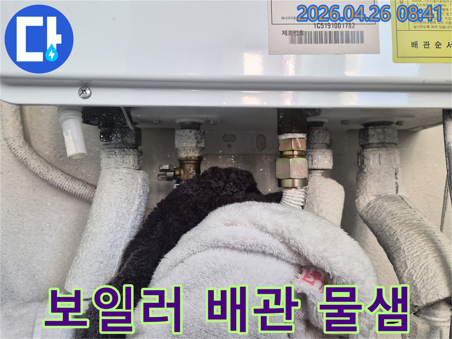 보일러 배관에서 물이 새어 나와- 주변에 물기가 맺히고 수건으로 닦아낸 흔적이 있는 모습