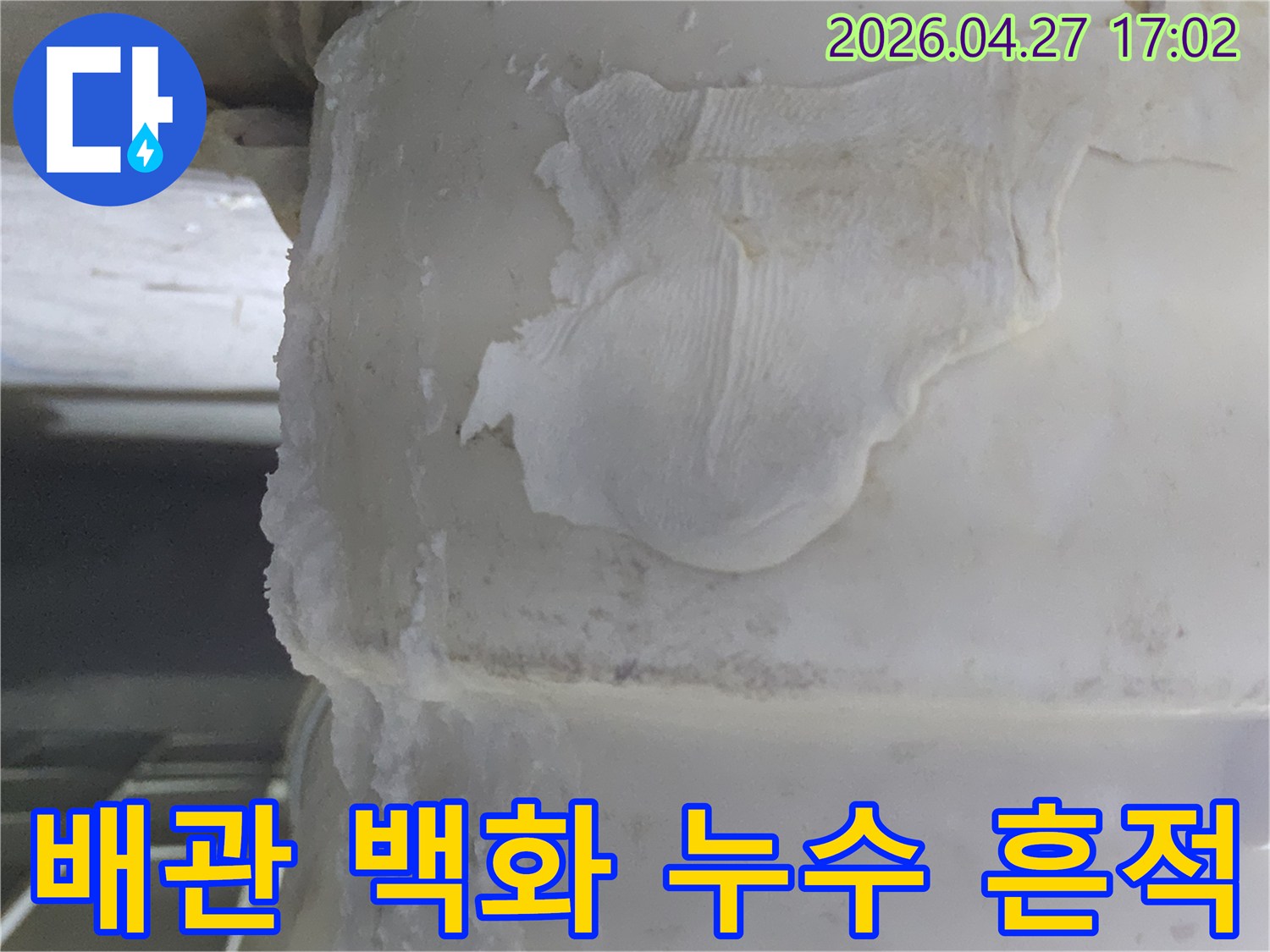 오랜 기간 물이 새면서-하얗게 굳어버린-배관 주변의-석회질 침전물과-물때 흔적을-보여주는 이미지입니다.