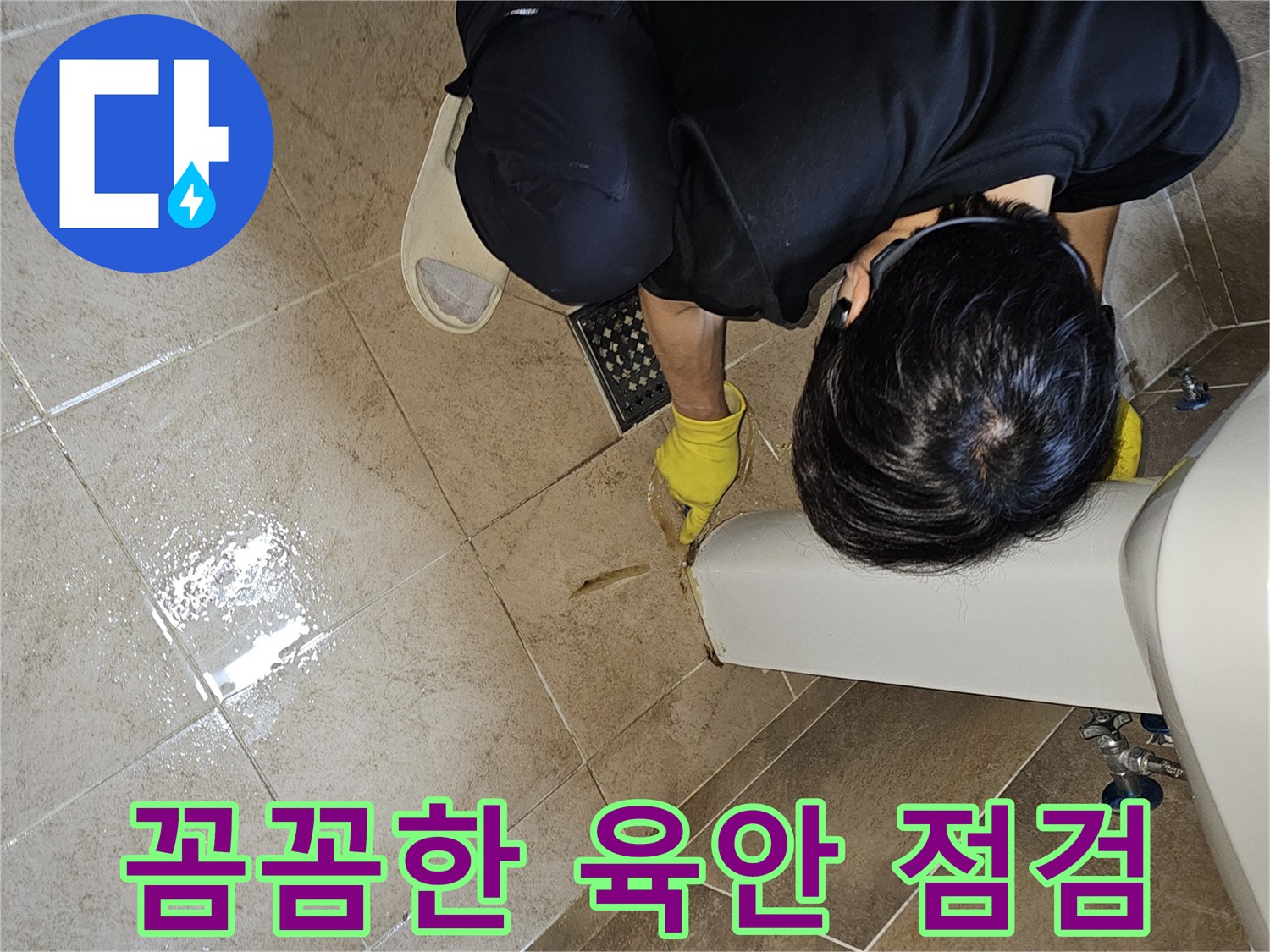 전문 엔지니어가-노란 장갑을 끼고-욕실 바닥의 젖은 타일과-세면대 하단부를-집중적으로 관찰하며-누수 지점을 꼼꼼하게 확인하고 있습니다
