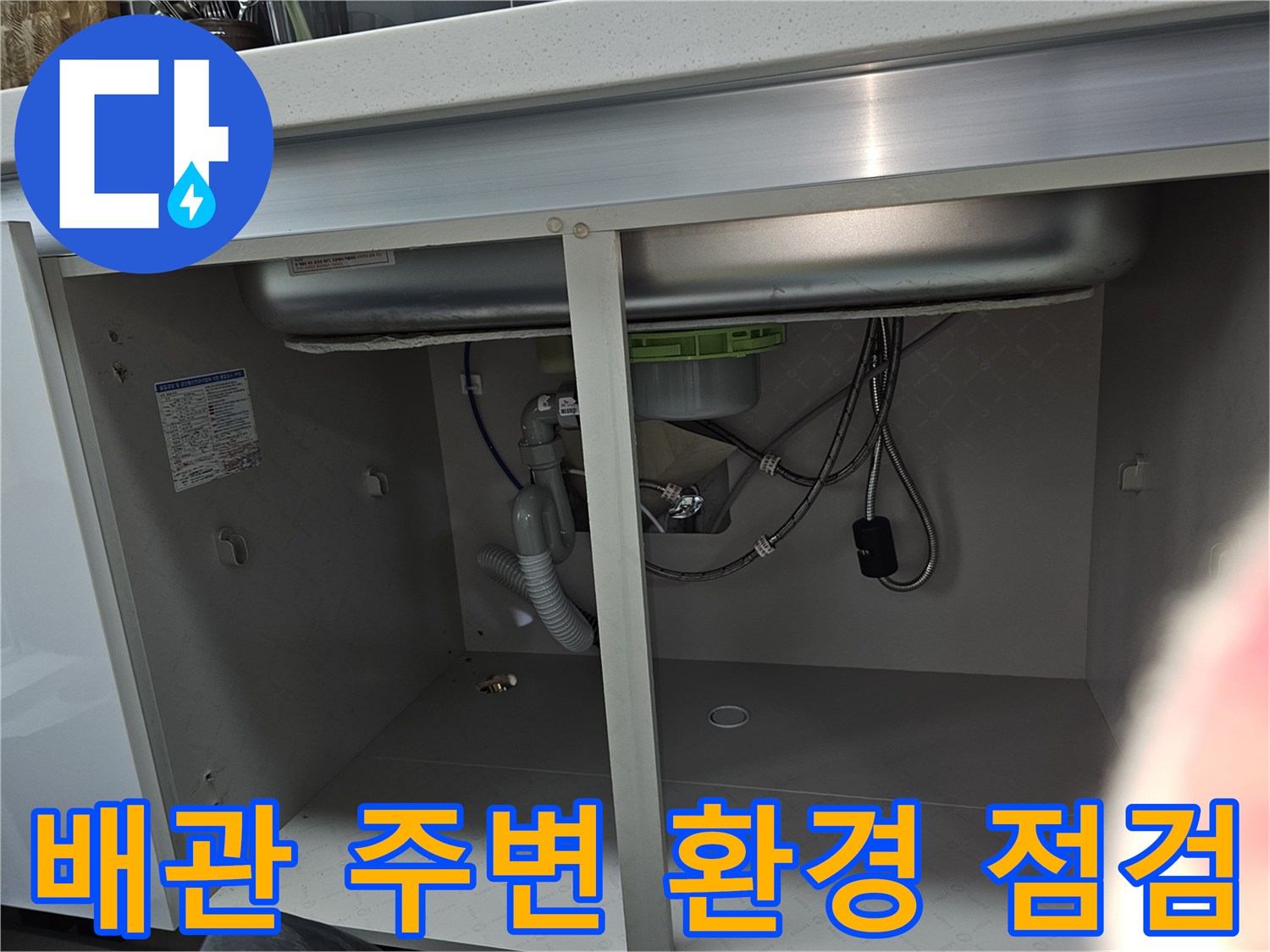 싱크대 하부 배관 주변의 전체적인 환경을 보여주는 이미지로-누수 발생 가능성이 있는 요인들을 종합적으로 점검하고 있습니다.
