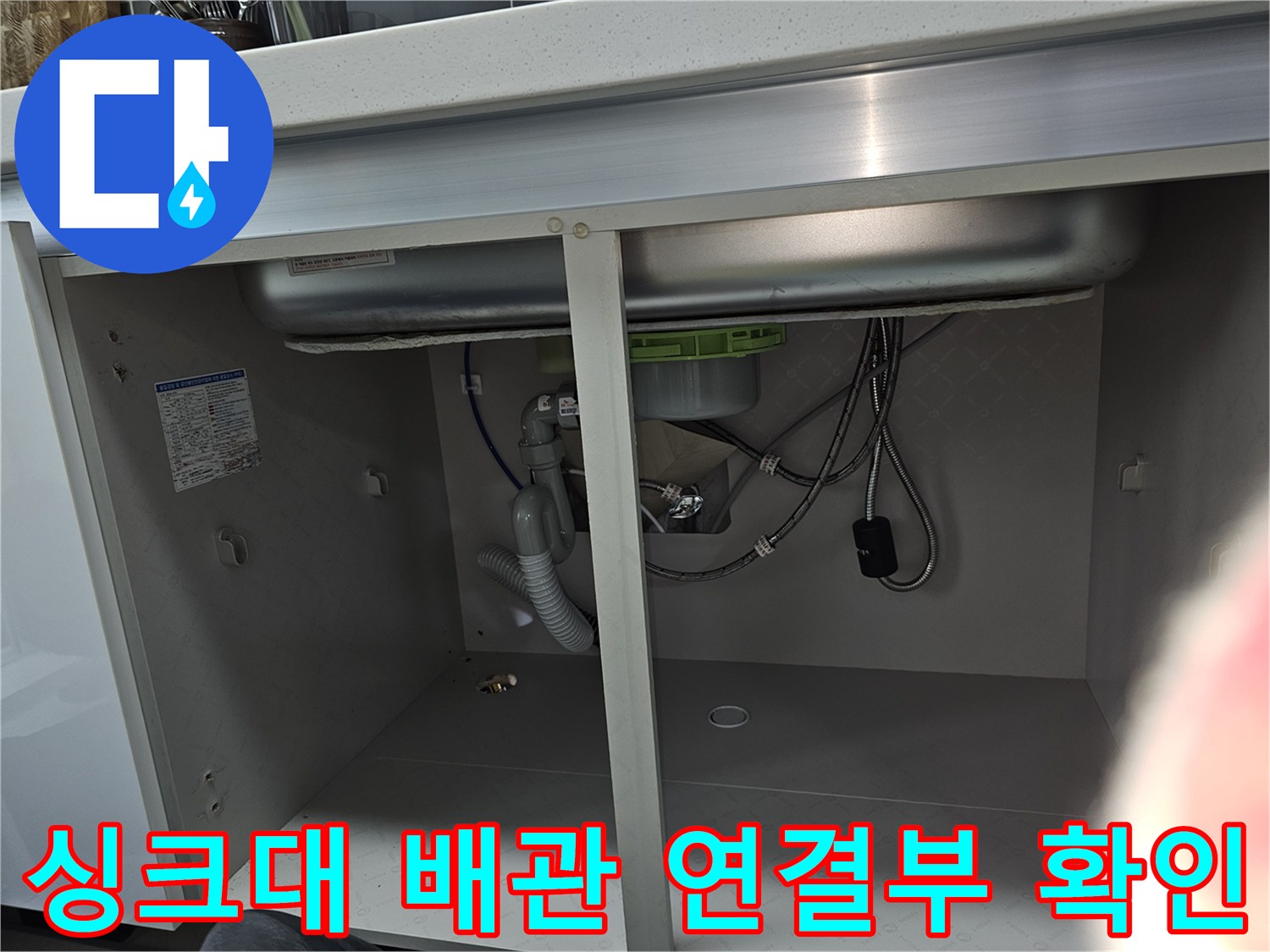 주방 싱크대 하부의 배관 연결 부위를 근접 촬영한 이미지로-누수 발생 가능성이 높은 지점을 집중적으로 점검하고 있습니다.
