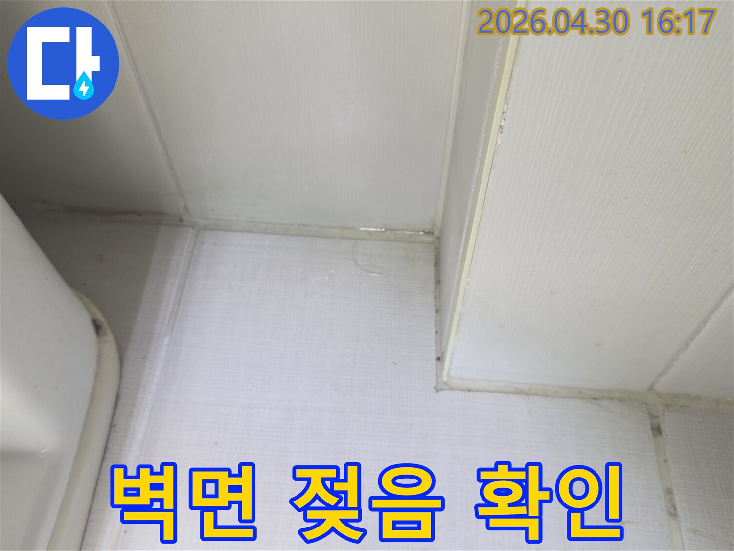 벽과 천장 사이에서 물이 새어 나와-벽면이 축축하게 젖어있는 상태를 보여주는-누수 발생 현장의 증거 사진