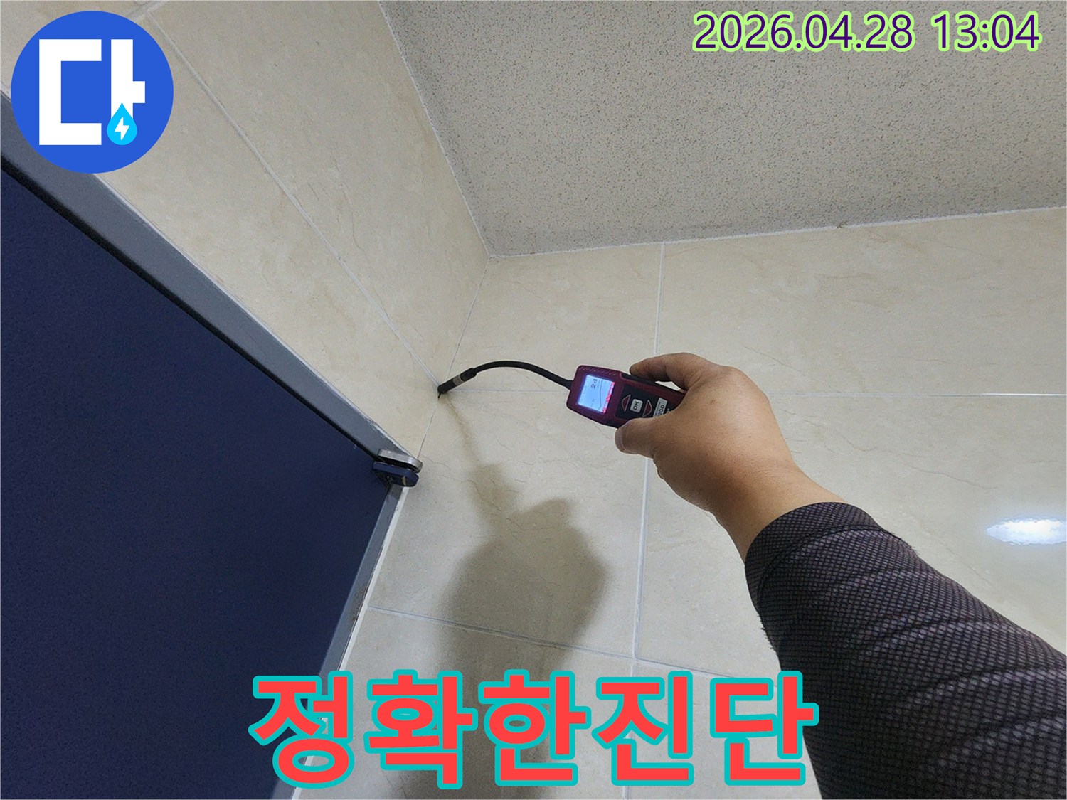 숙련된 누수 전문가가-첨단 장비를 활용하여-욕실 벽면과 바닥 경계의-미세한 누수 흔적을-꼼꼼히 확인하고 있습니다