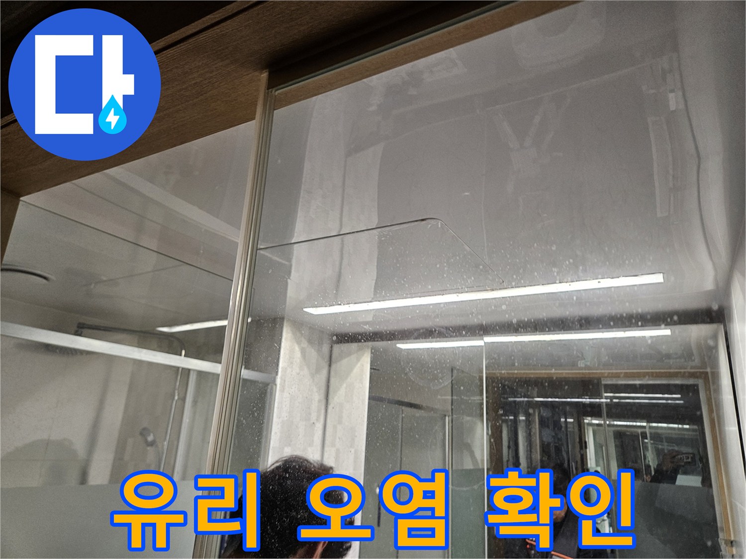 유리-벽면에-남은-물-자국과-오염-흔적-누수-전문가가-누수-피해-상황을-조사하는-모습