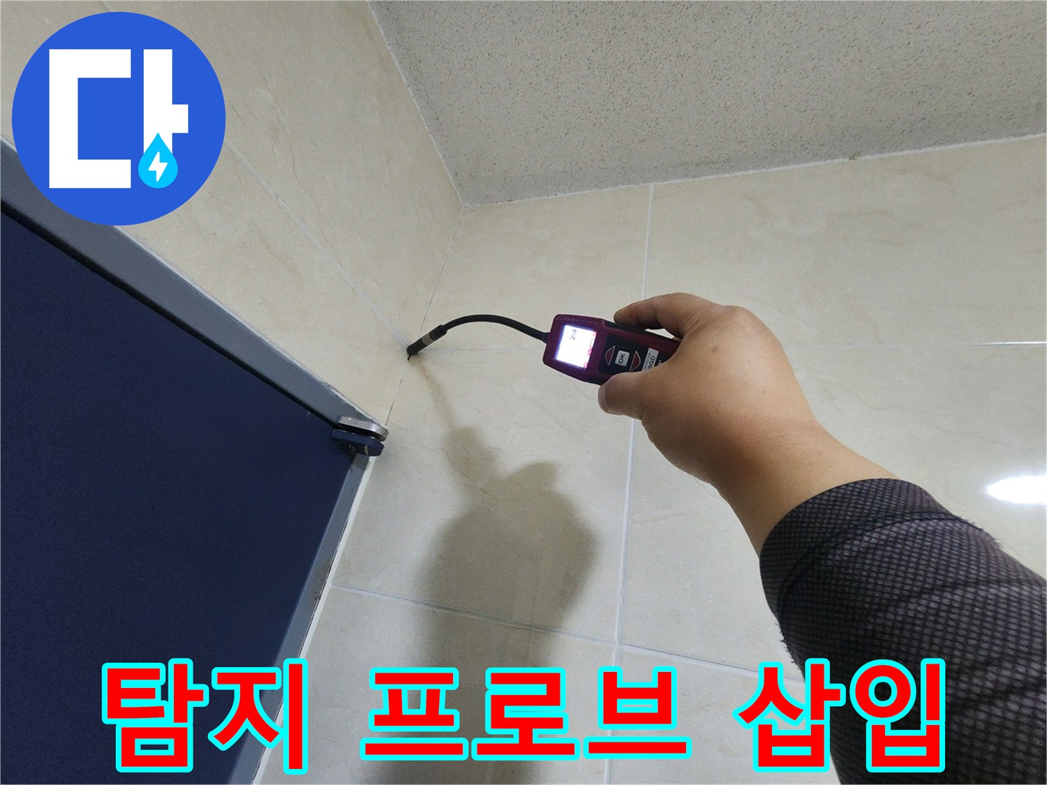 누수 전문가가-정밀 탐지 장비의 프로브를-벽면 틈새에 삽입하여-누수 원인을 분석하고 있습니다.