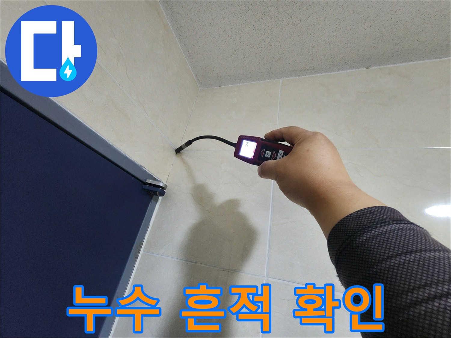 숙련된 엔지니어가-정밀 탐지 장비로-벽면 타일의 미세한 누수 흔적을-꼼꼼하게 확인하고 있습니다.