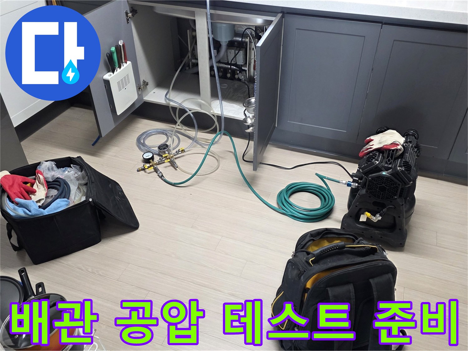 누수 지점을 찾기 위해 싱크대 하부에 연결된 공압 테스트 장비 모습입니다.