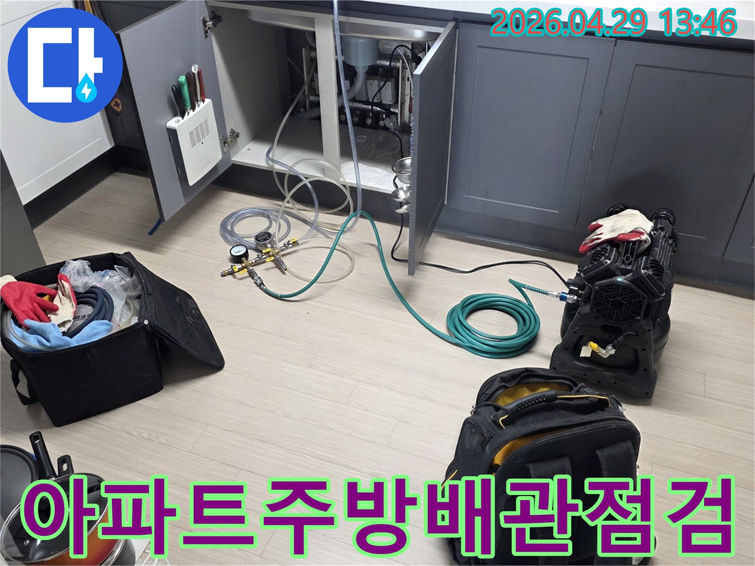 비산동 아파트 주방 싱크대 하부에서-누수 확인을 위한-배관 점검 장비와-호스를 연결하여-테스트를 준비하는 모습입니다