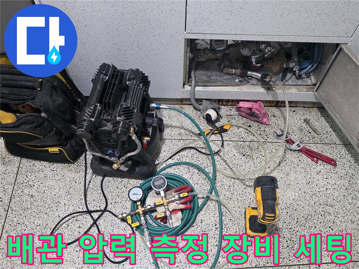 싱크대 하부 점검구 내부의 배관과 연결된 압력 측정용 호스 및 게이지