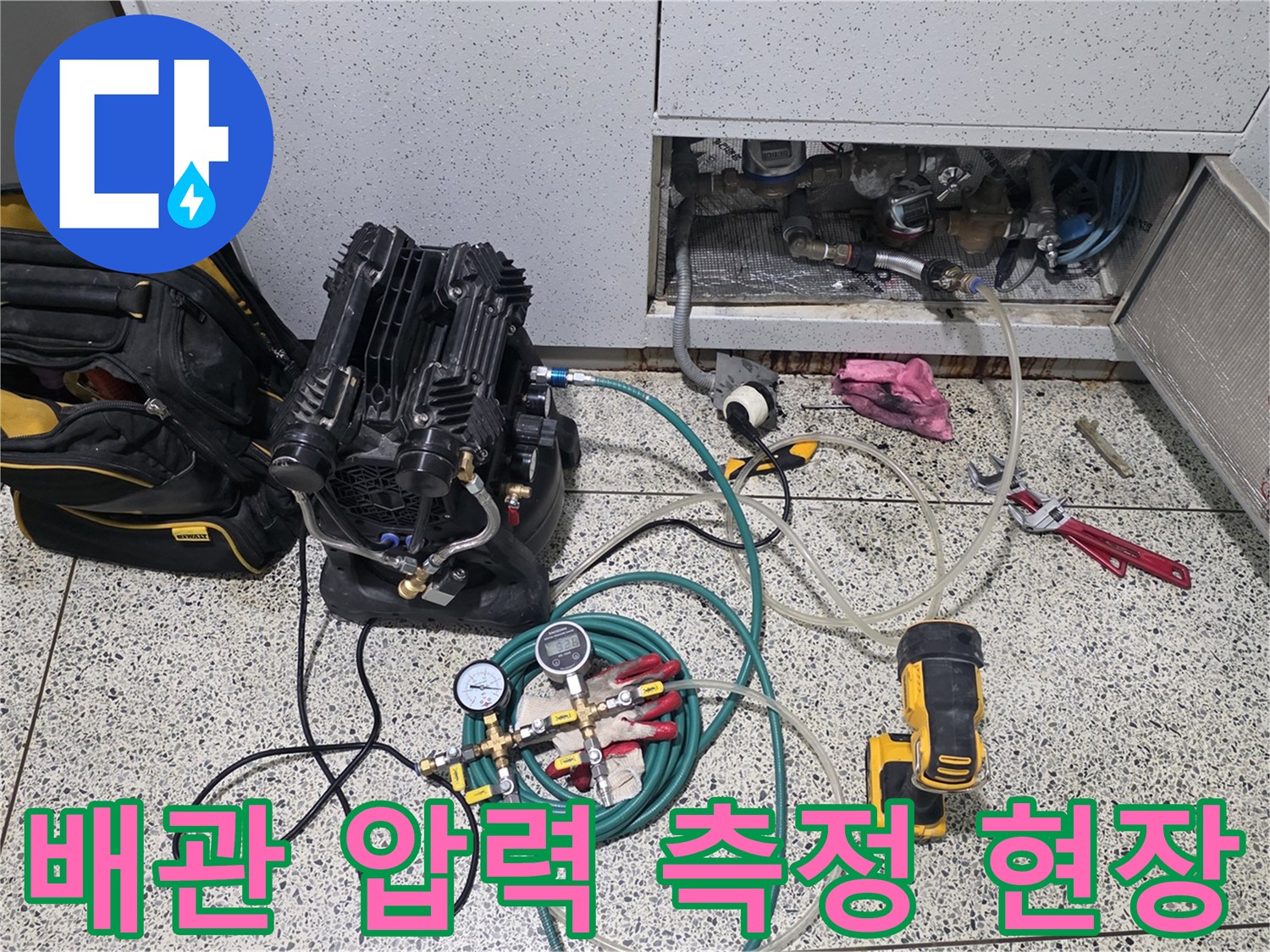 점검구 내부 배관에 연결된 디지털 압력계와 에어 호스 세팅 모습