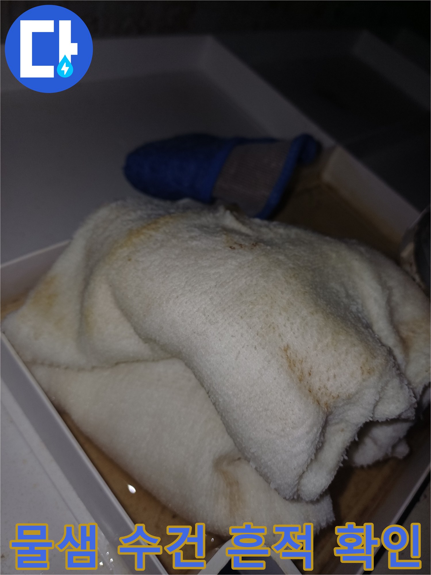 물에 젖어 얼룩진 수건이 놓인 모습으로-누수로 인한 피해가 진행 중임을 시각적으로 보여줍니다.