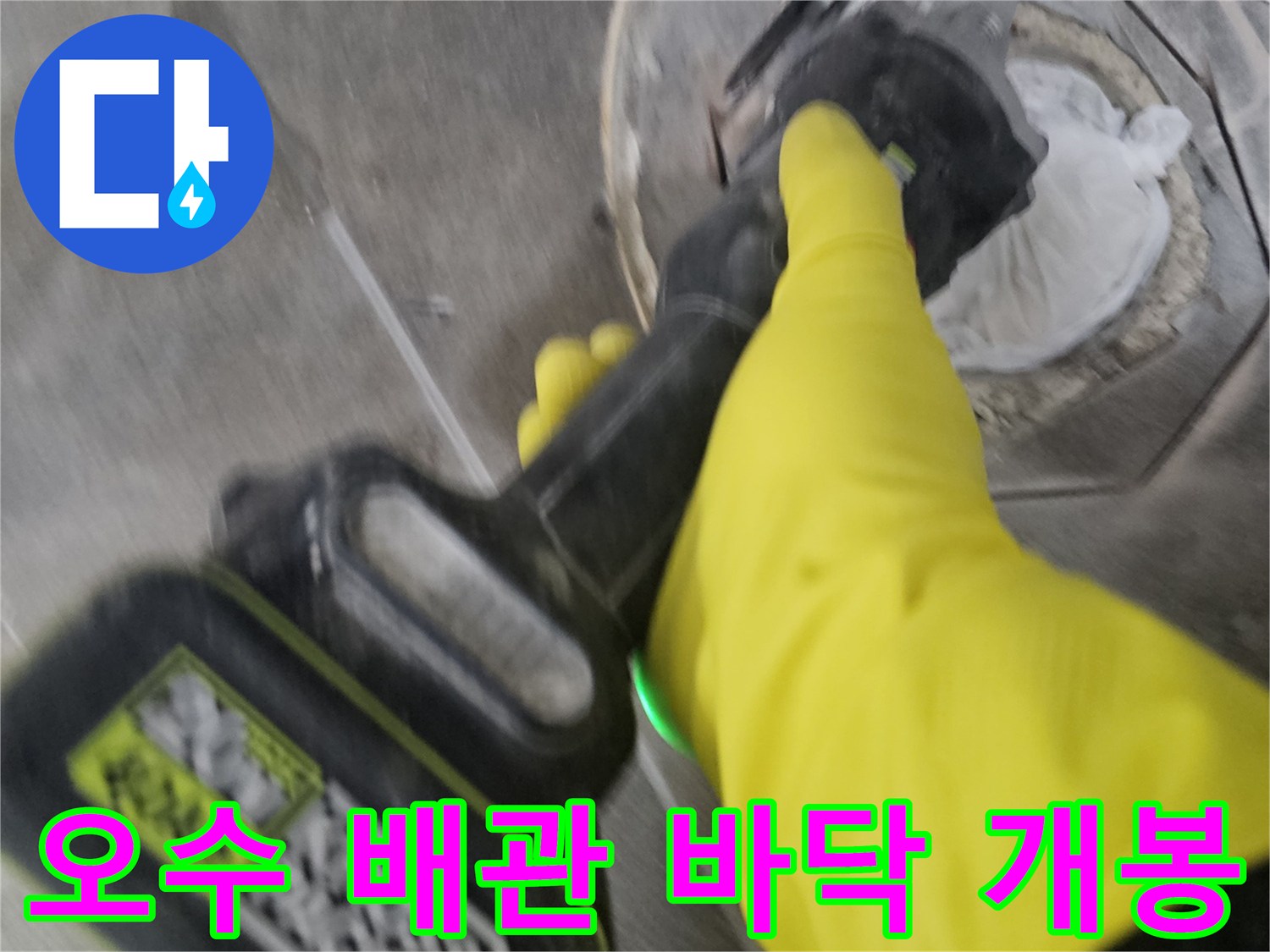 노란색 작업 장갑을 착용한-기술자가-전동 공구로-오수 배관 주변의 바닥을-조심스럽게 개봉하는 모습입니다.