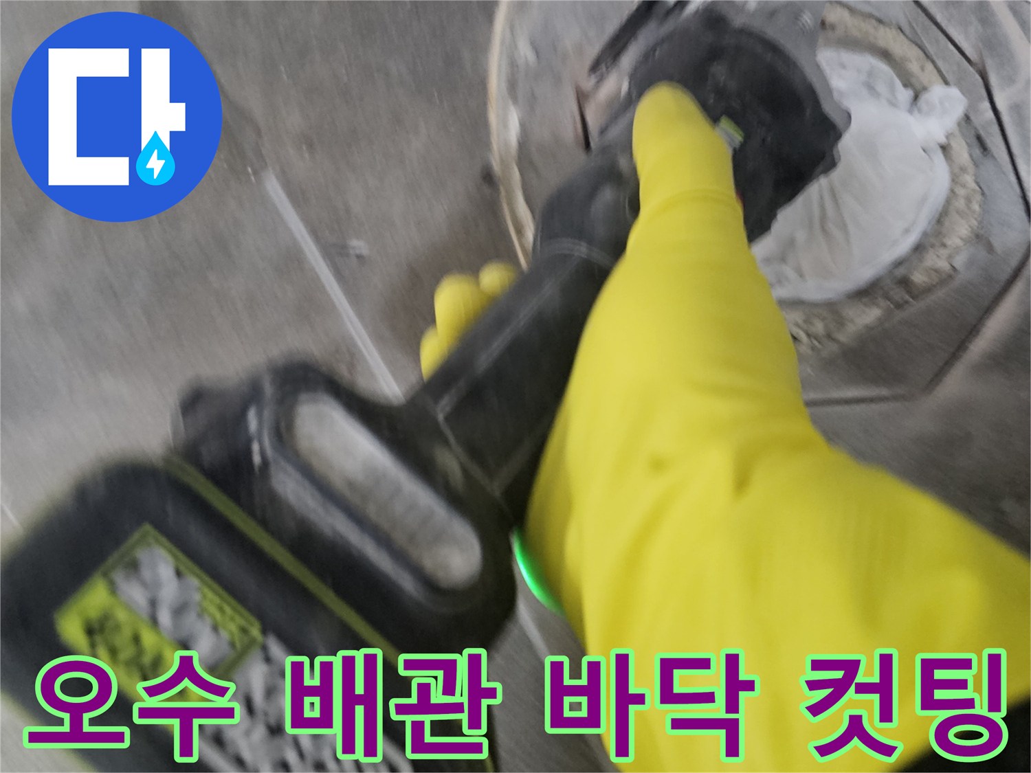 노란색 작업 장갑을 착용한-기술자가-전동 공구로-오수 배관 주변의 바닥을-조심스럽게 컷팅하는 모습입니다.