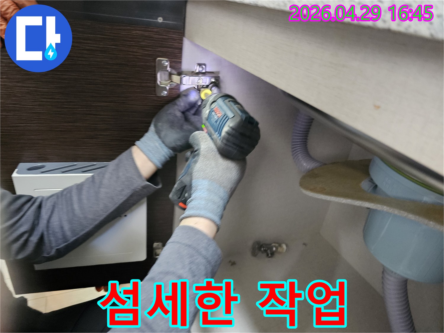 누수 전문가가-섬세한 손길로-싱크대 하부장-패널을-분리하는-모습