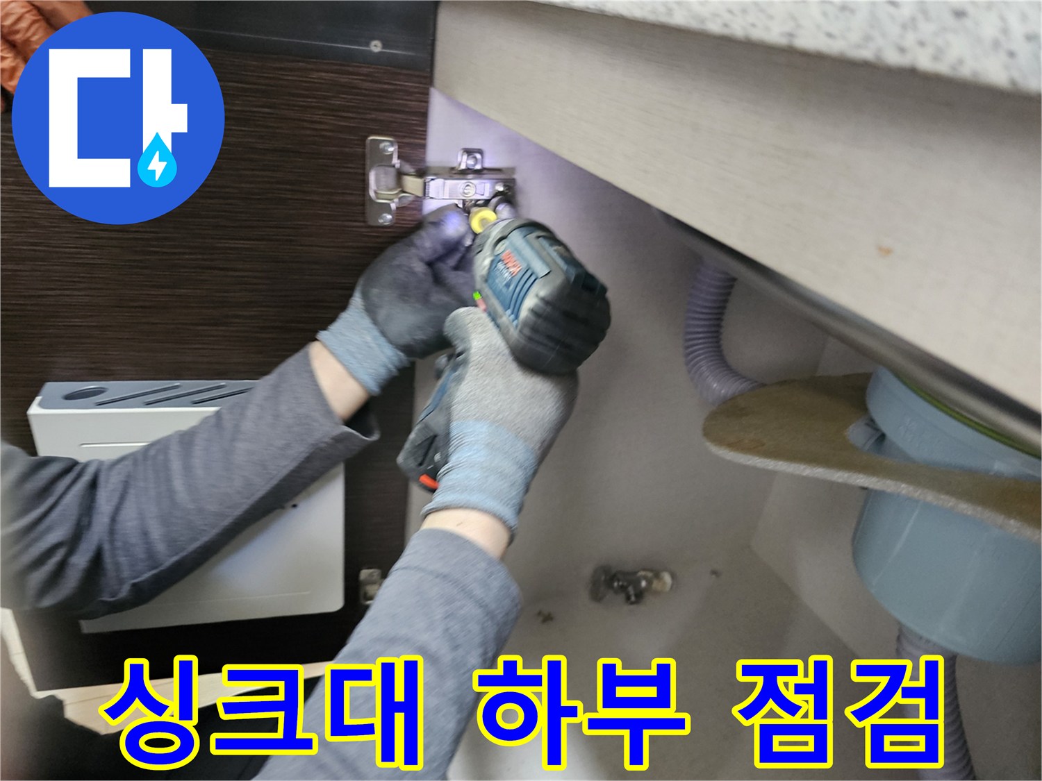 누수 전문가가-싱크대 하부를-점검하기 위해-패널을-분리하는-모습