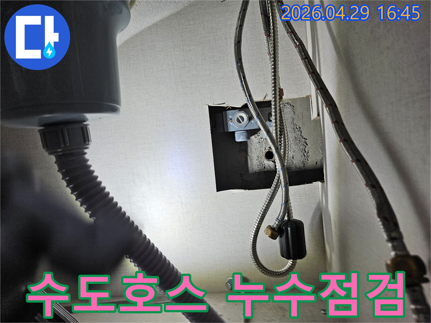 빌라 싱크대 하부의-수도 연결 호스에서-누수 여부를-점검하는 모습입니다.