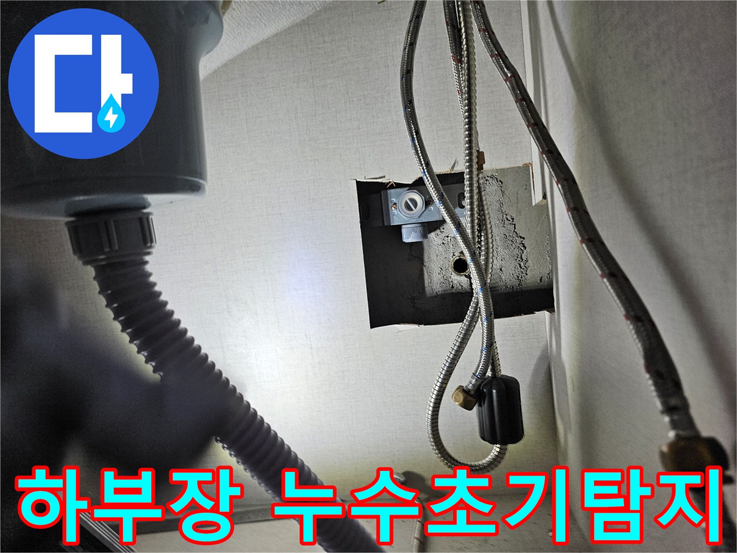 싱크대 하부장 내부에서-수도 배관과-연결 부위를-초기 누수 탐지를 위해-점검하는 모습입니다.