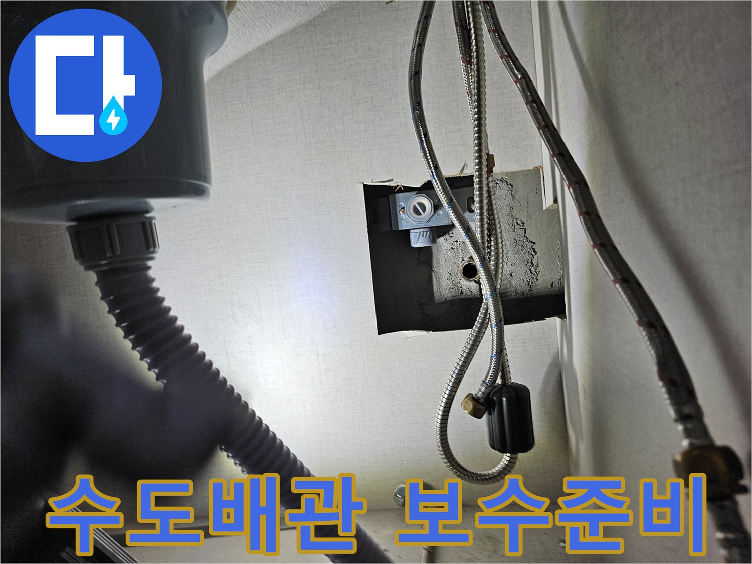 싱크대 하부장 내부의-수도 배관 연결 부위를-점검하고-보수를 준비하는 모습입니다.