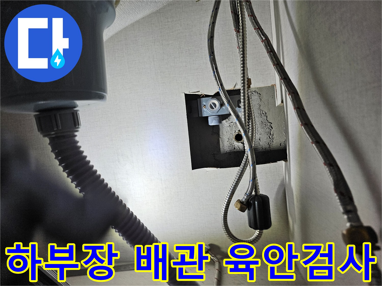 주방 싱크대 하부장 내부의-수도 배관과-연결 부위를-육안으로-꼼꼼히 검사하는 장면입니다.
