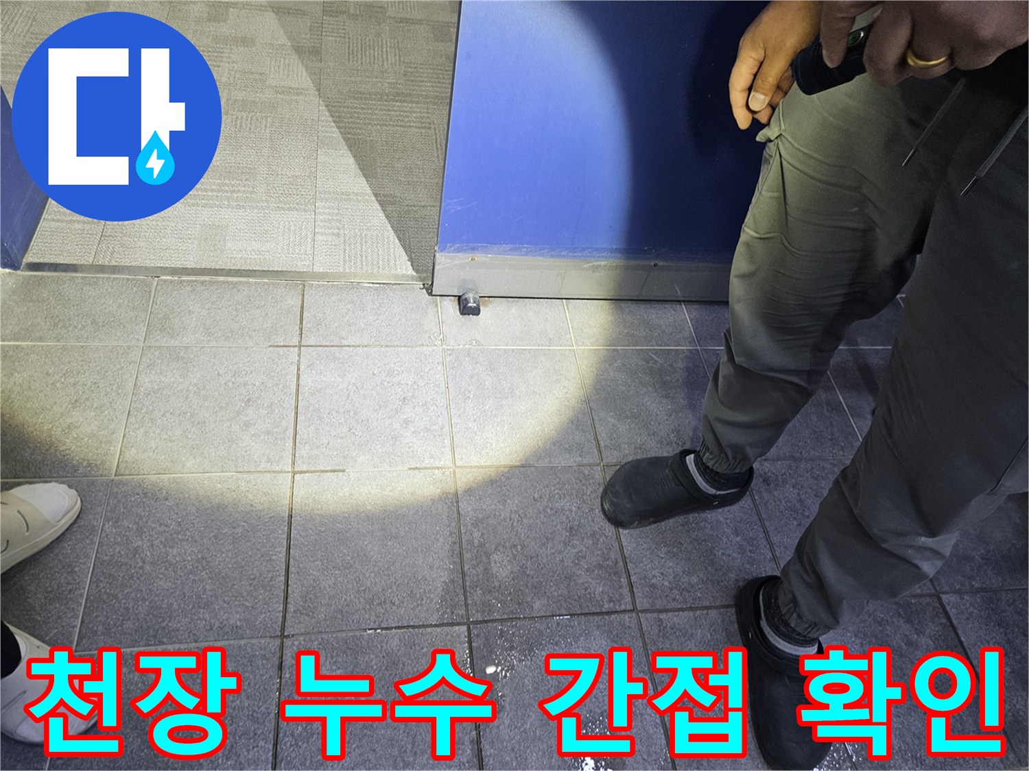 누수 전문가가 바닥에 고인 물기를 확인하며-천장 누수와 연관성을 파악하는 초기 진단 모습입니다.