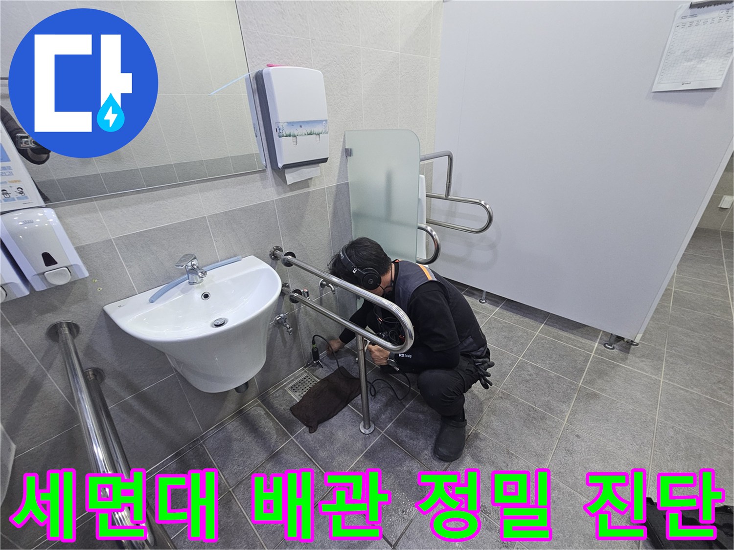 누수 전문가가-청음식 탐지기로-화장실 세면대 하부 배관에서-누수음을 정밀하게 듣고-원인을 파악하는 중