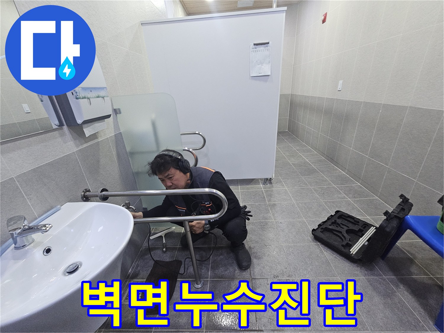 전문 엔지니어가-청음 장비로-벽면의 누수 지점을 정밀하게 진단하고 있습니다.