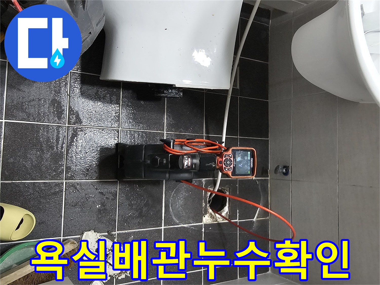 젖은 화장실 바닥에서-누수 원인 파악을 위해-내시경 장비가 사용되고 있습니다.