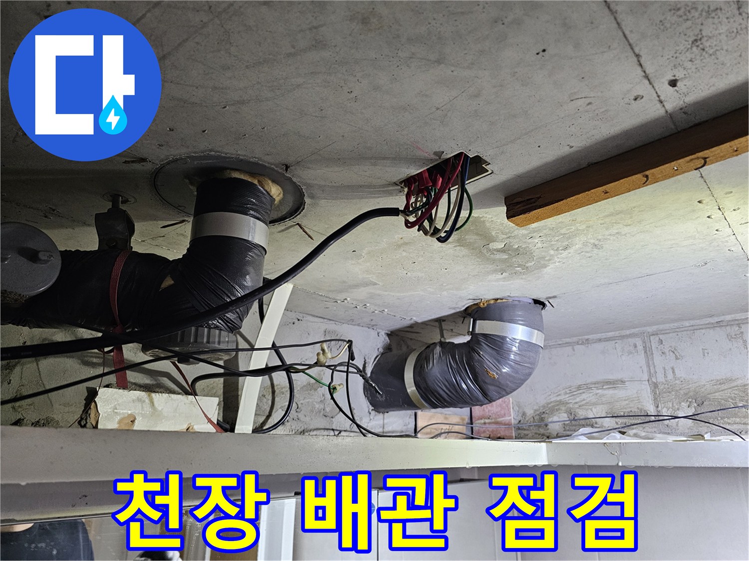 콘크리트 천장 아래-설치된-배관과-전기 배선이-엉켜있는-누수 현장-사진입니다.