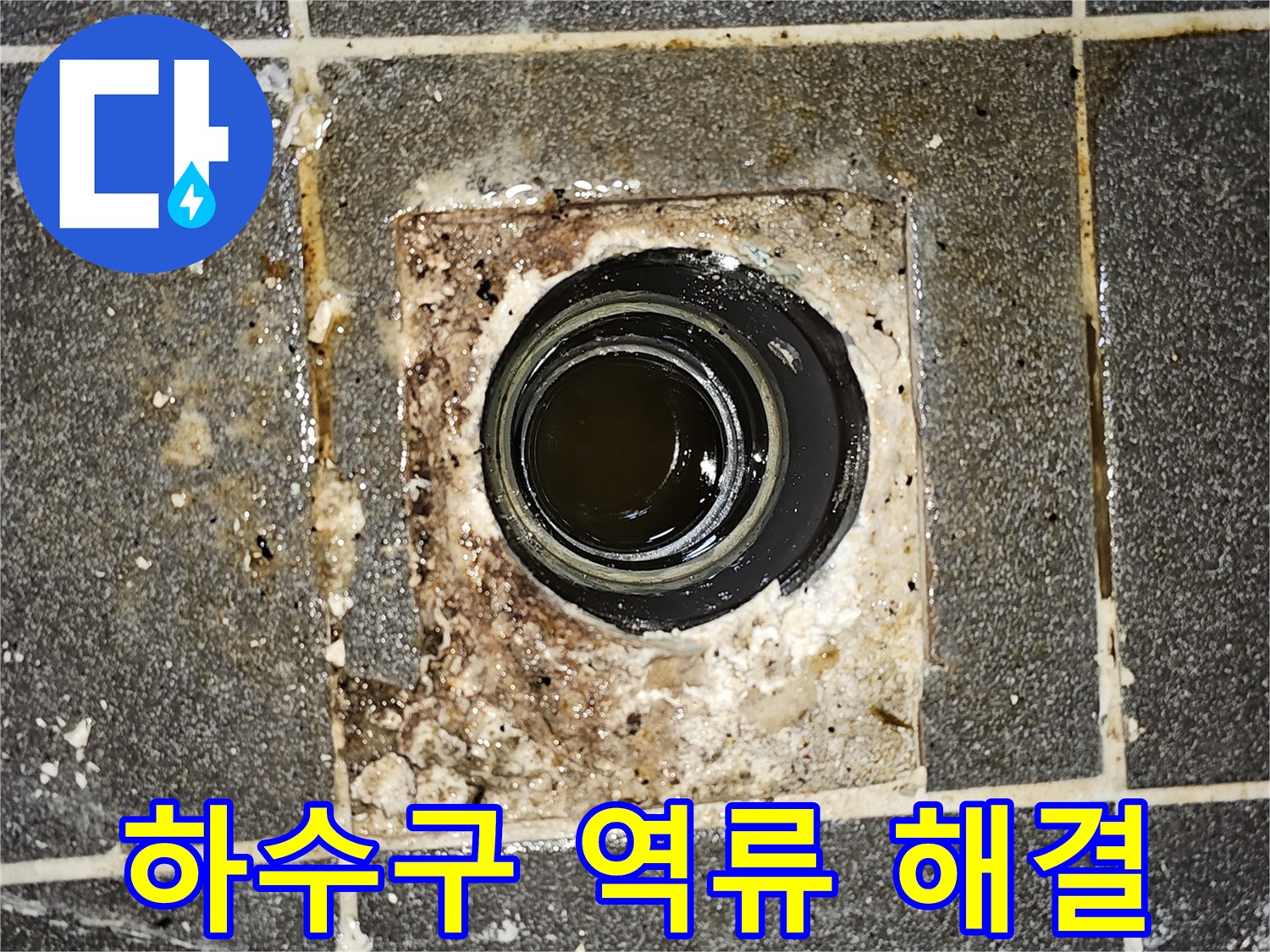 하수구에서 물이 역류하여-바닥에 고여있는 모습을 보여주는-심각한 배관 막힘 현장의 사진입니다.