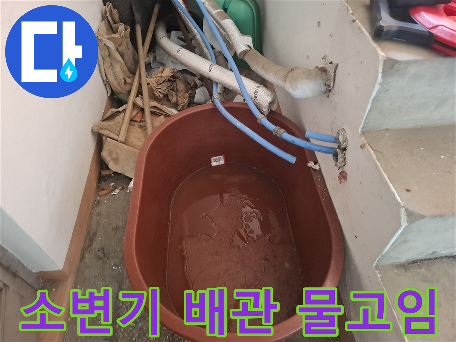 소변기 주변 배관에서 흘러나온 물이 대야에 고여 있는 모습