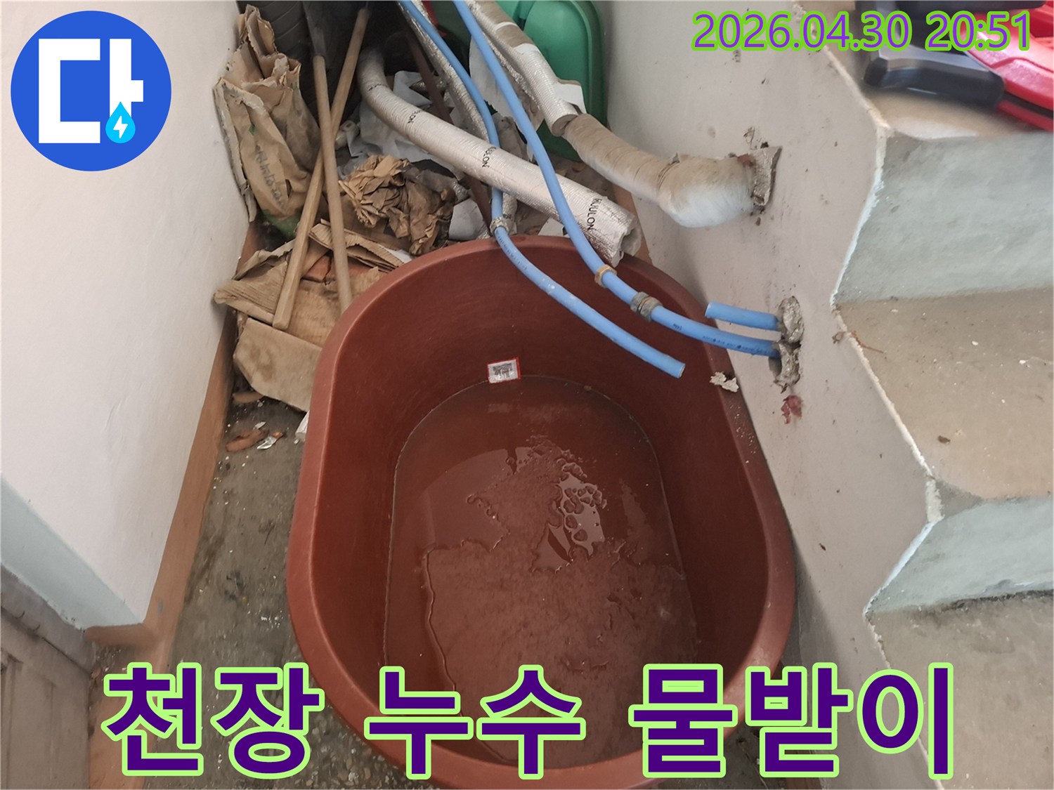 천장 누수가-발생한 현장에서-물이 떨어지는 것을-받아내기 위해-설치된-갈색 물통입니다